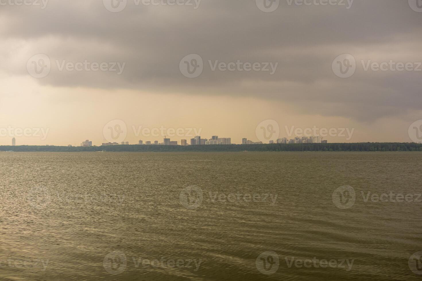 Dramatic sky behind the lake with cityscape in the background photo