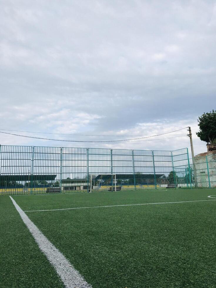 Soccer field with green turf and cloudy sky in afternoon photo