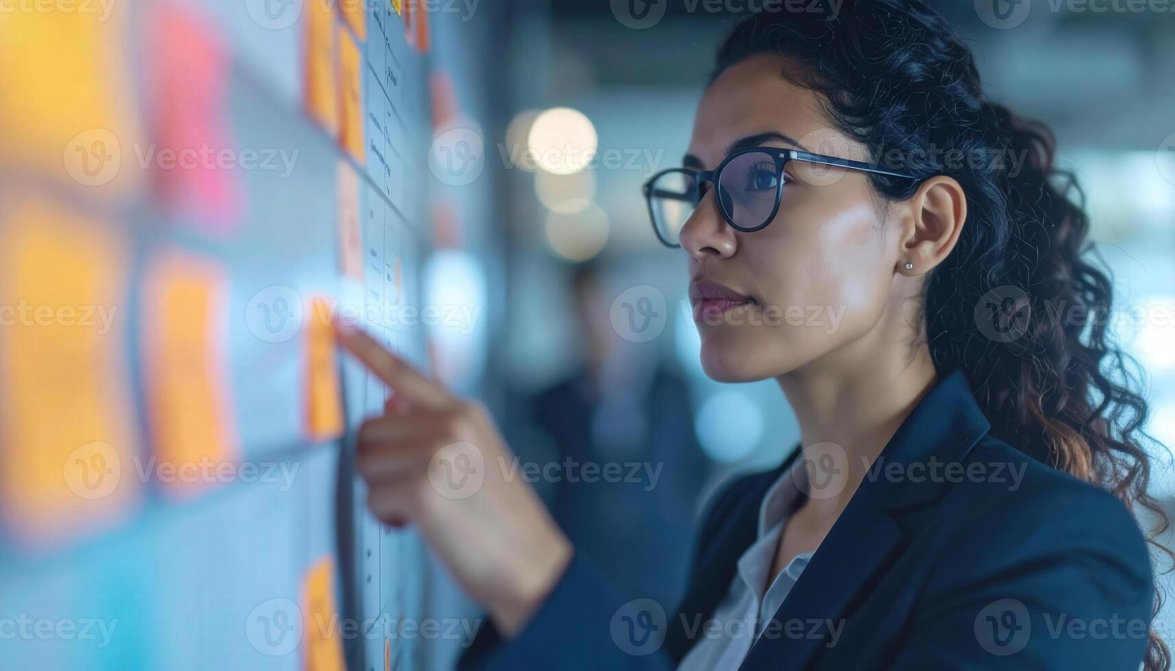 Businesswoman Analyzing Data Strategy with Post-It Notes on Wall photo