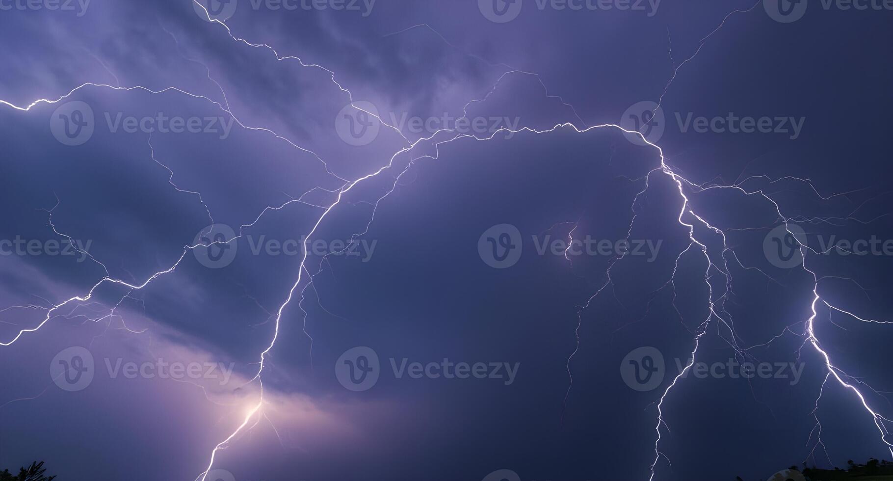 Lightning strikes over a dark sky with trees in the background photo