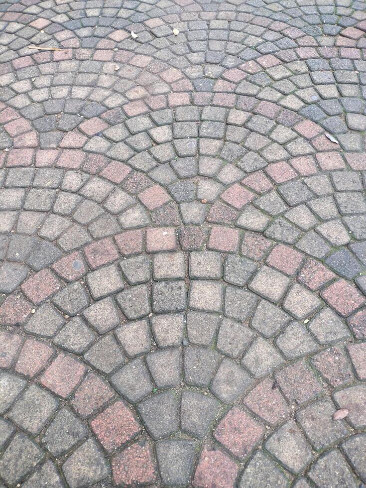 The image displays a surface paved with cobblestones, arranged in a decorative, fan-like pattern photo
