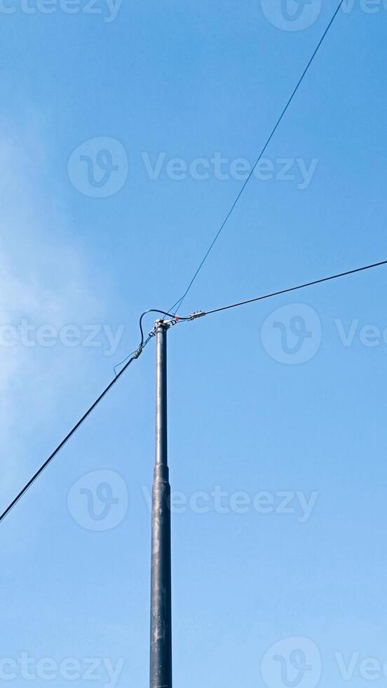 A pole with wires and a blue sky photo