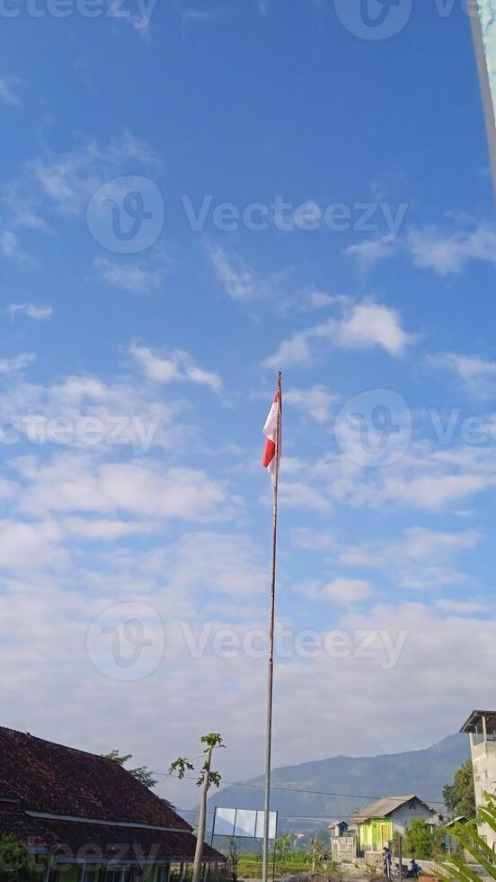 A flag pole with a red and white flag photo