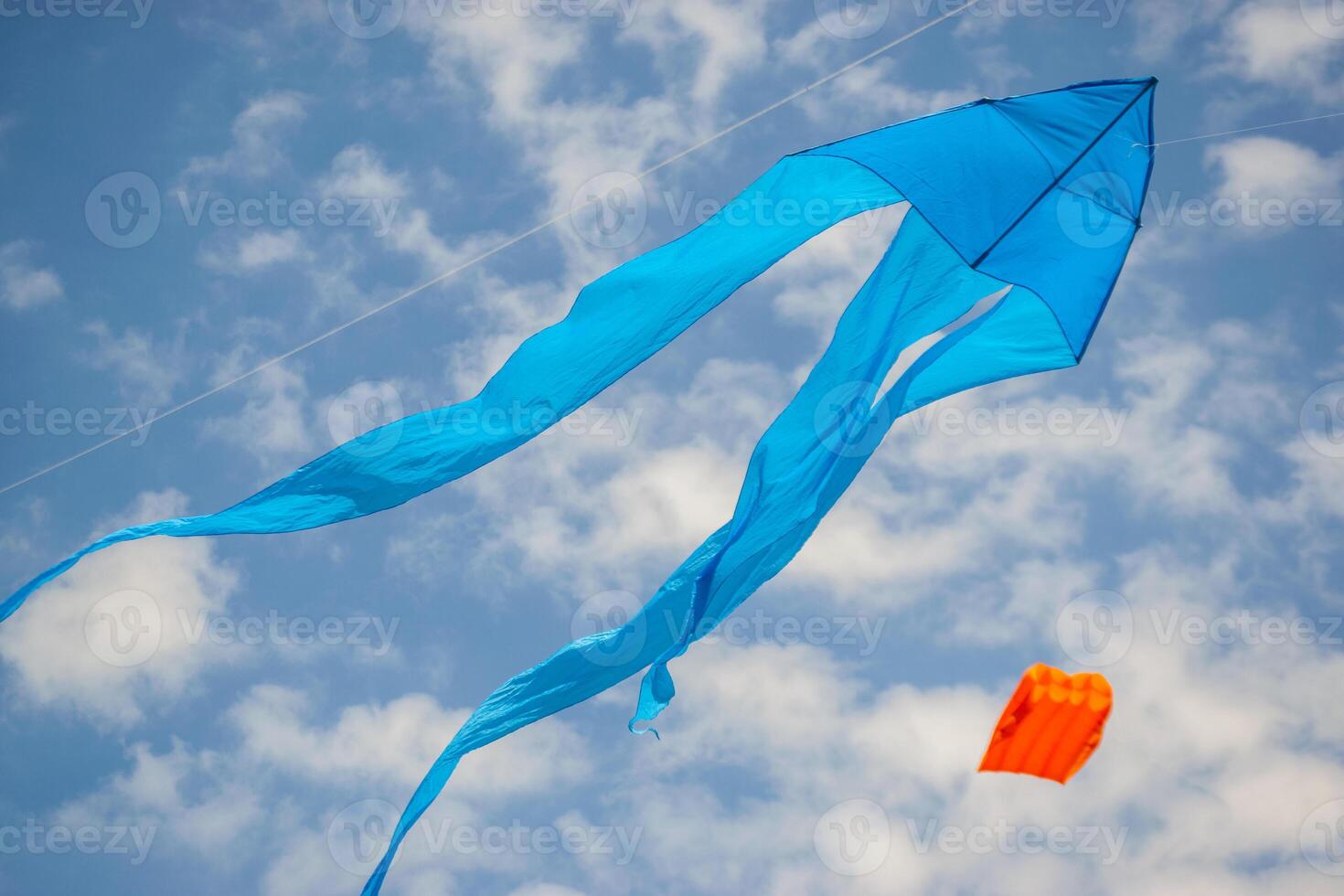Kite Festival. Blue and Orange Kites Dancing in Partly Cloudy Sky photo