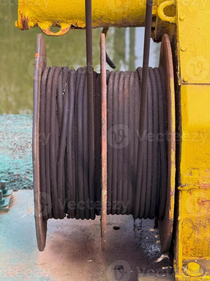 Industrial Cable Spool on Yellow Winch with Water Background photo