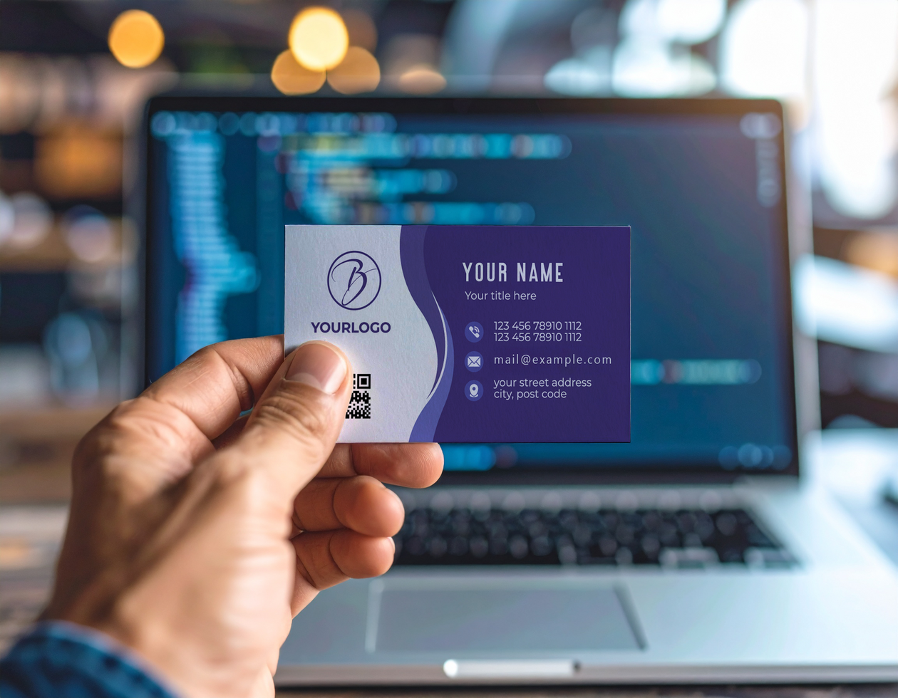 Developer Holding Business Card Mockup in Front of Laptop psd