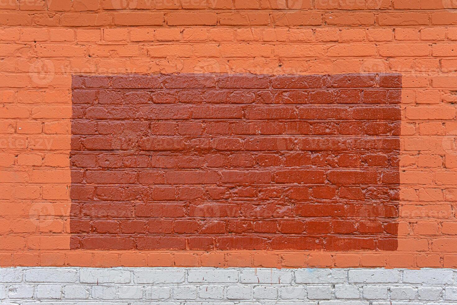 A dark red triangle is painted on a red brick wall. A fancy background for the inscription. photo