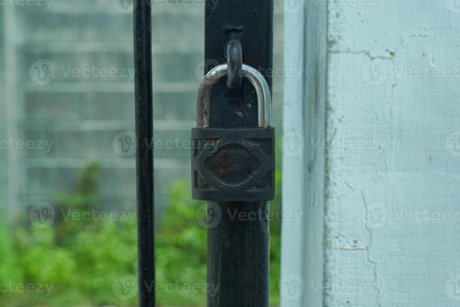 A rusty padlock securing a gate photo