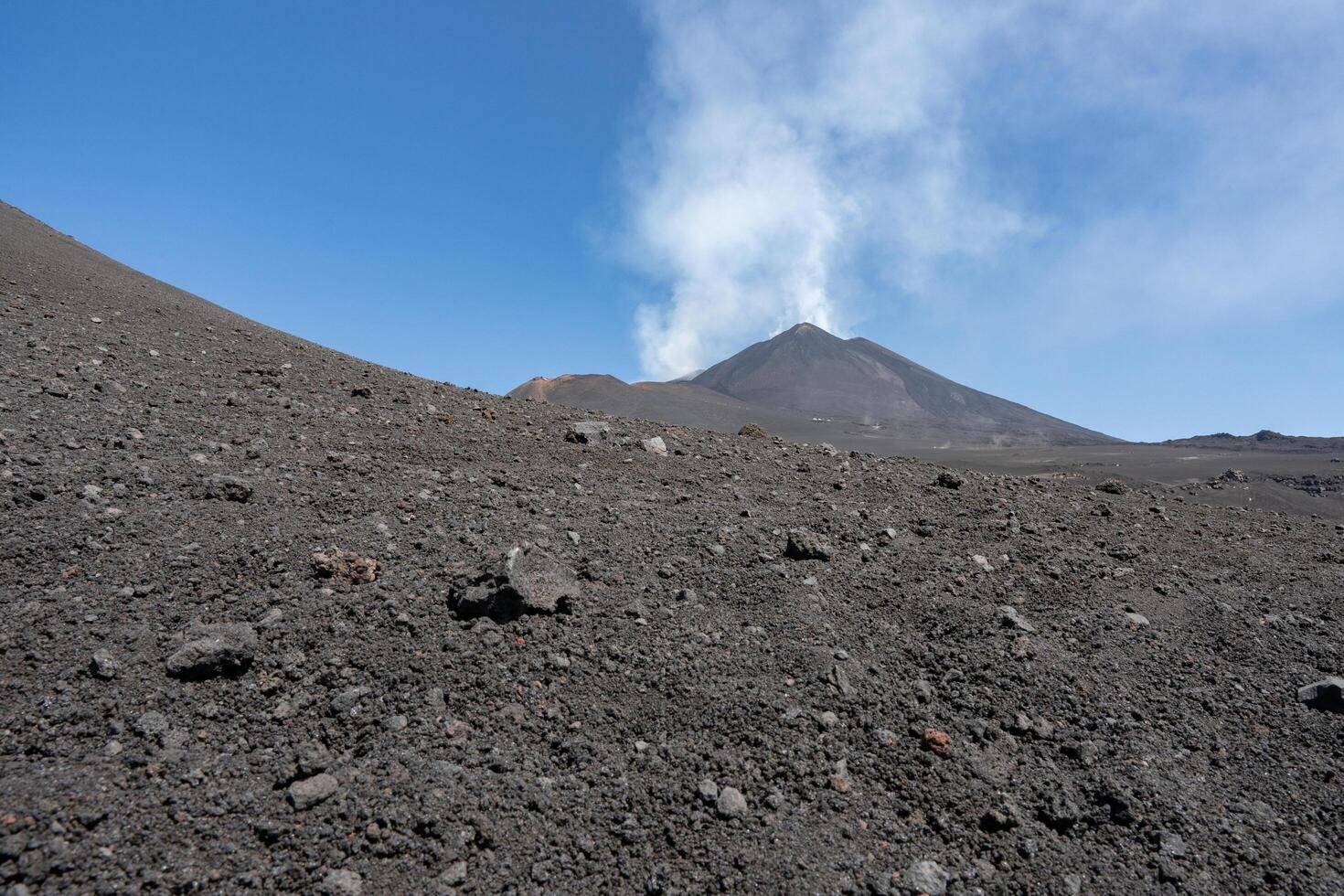 Etna volcano view from the bottom with rocks in foreground photo