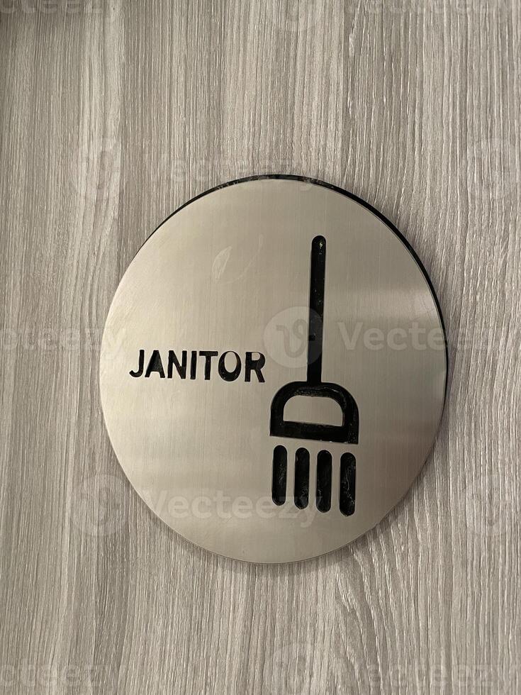 Janitor Room Door Sign with Broom Icon on Brushed Metal Circle for Cleaning Services photo