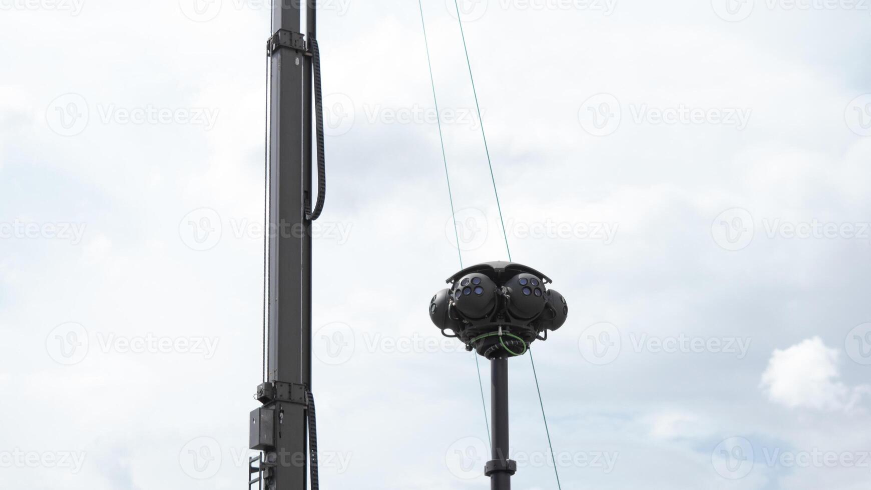 High-tech surveillance equipment positioned on a tall pole observes the area for tactical purposes during a military operation in a conflict zone. photo
