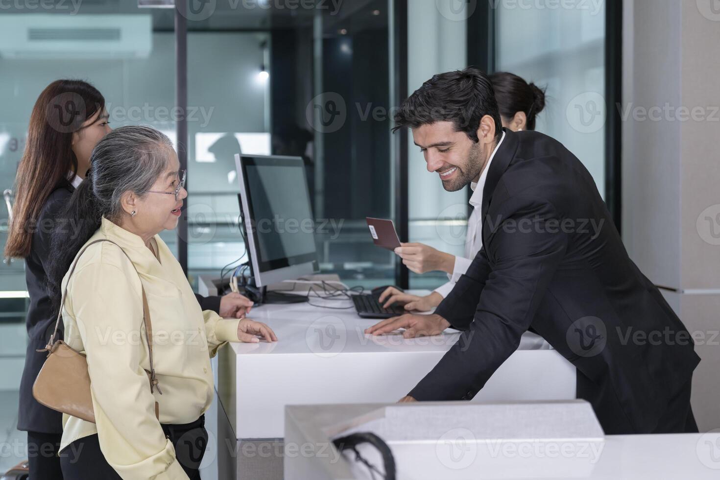 airline officers working at check-in counter,ground attendants service passengers that standing in queue in the airport,air transportation,airlines service photo