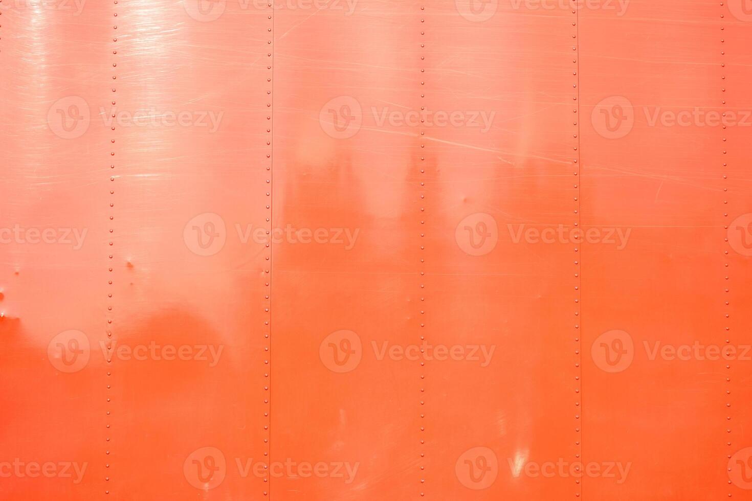 riveted metal plate painted red weathered and worn by time photo