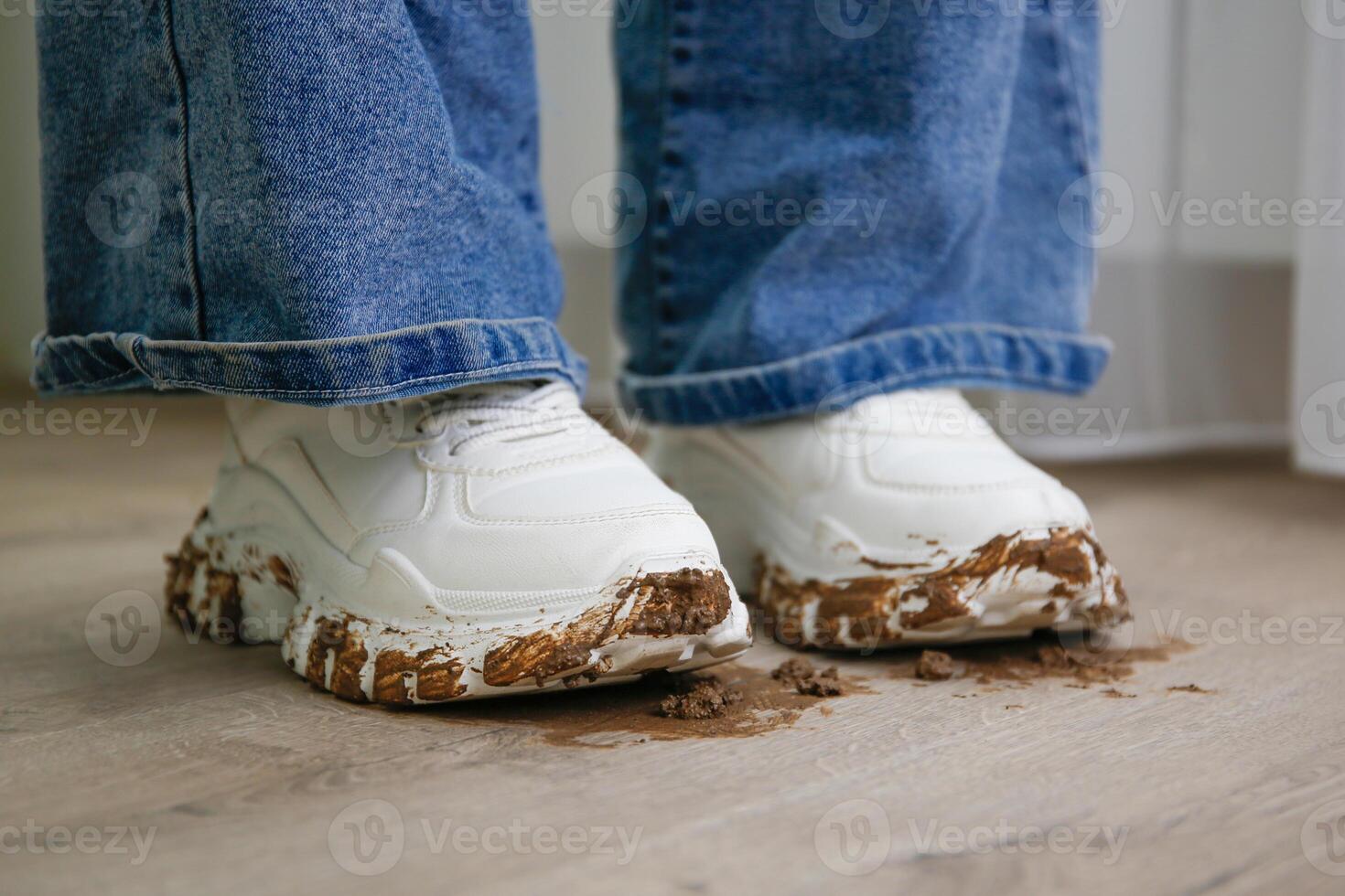 child walks around the house in dirty shoes. Concept of child soiled laminate flooring. photo