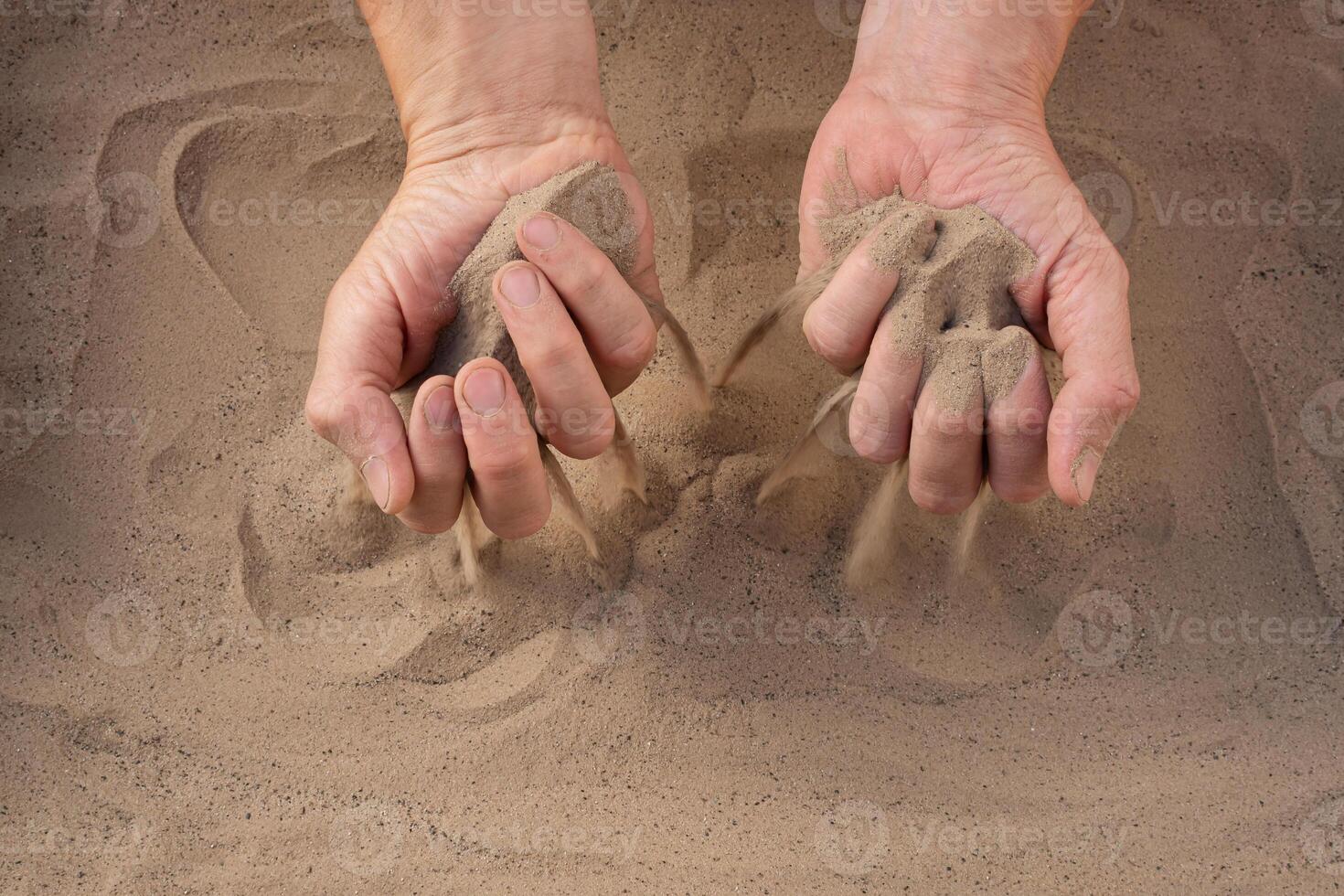 Sand of time. Close-up of sand falling from man's hand. photo