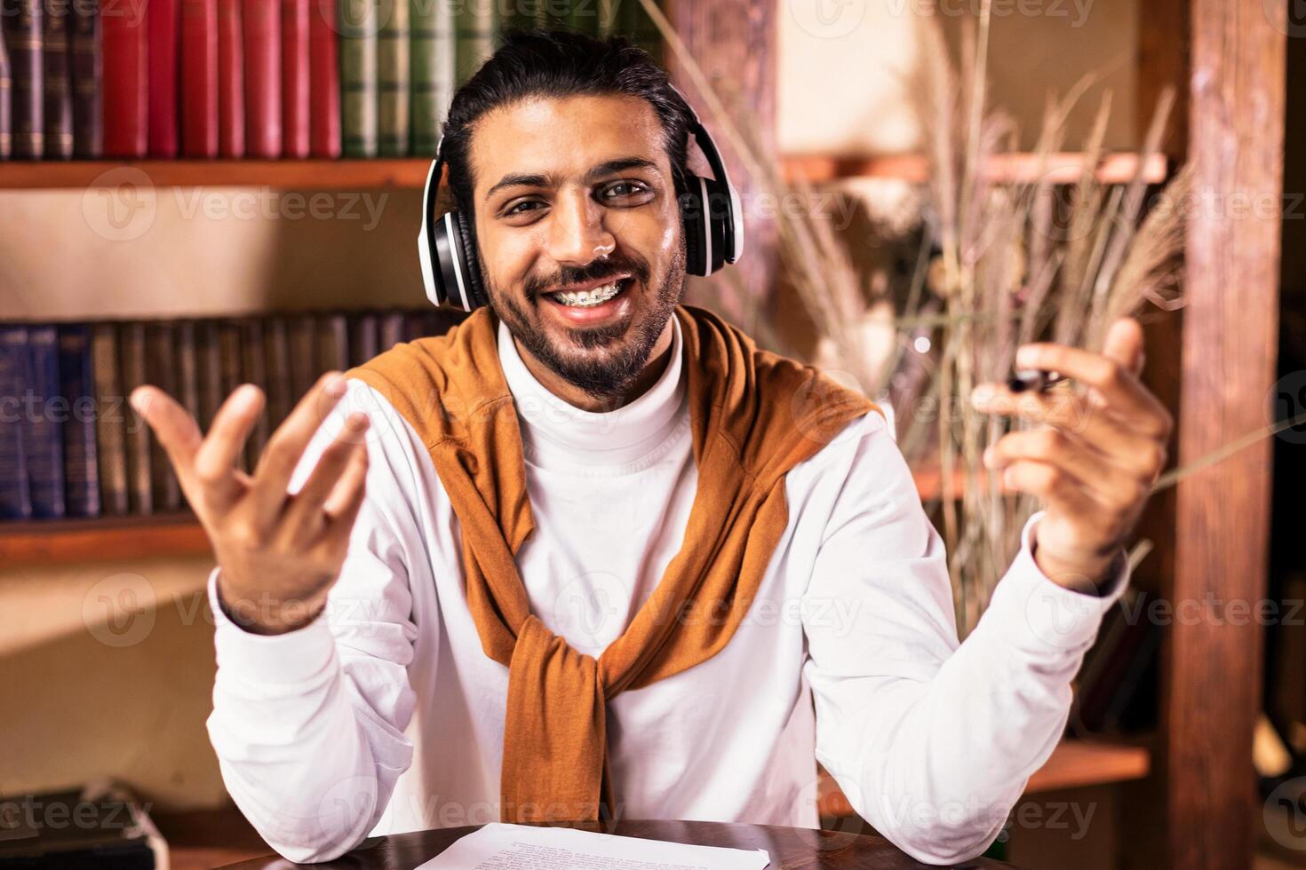 Indian Teacher Talking To Camera Teaching English Online Having Distant Class Sitting In Living Room, Working From Home. Modern Education And E-Teaching, Remote Training Concept photo