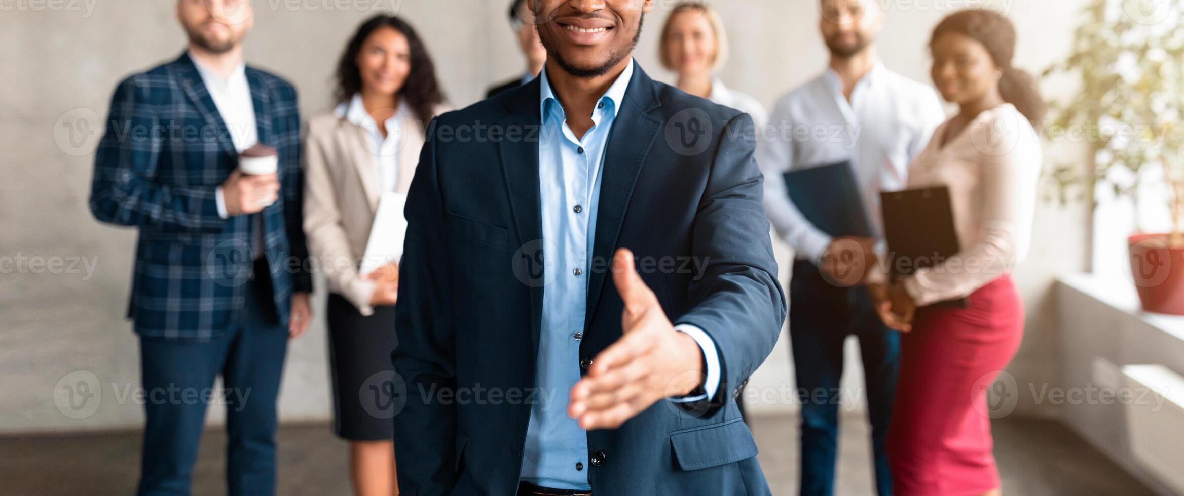Employment. Successful African American Businessman Stretching Hand For Handshake Greeting Standing With Employees Team In Modern Office, Smiling To Camera. Career Offer Concept. Selective Focus photo