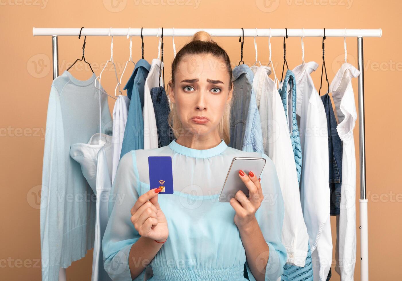 Debt, Failed Transaction, Lack Of Money. Portrait of sad upset female customer holding credit card with limit and using mobile phone, having problems with purchase in store and online payment photo