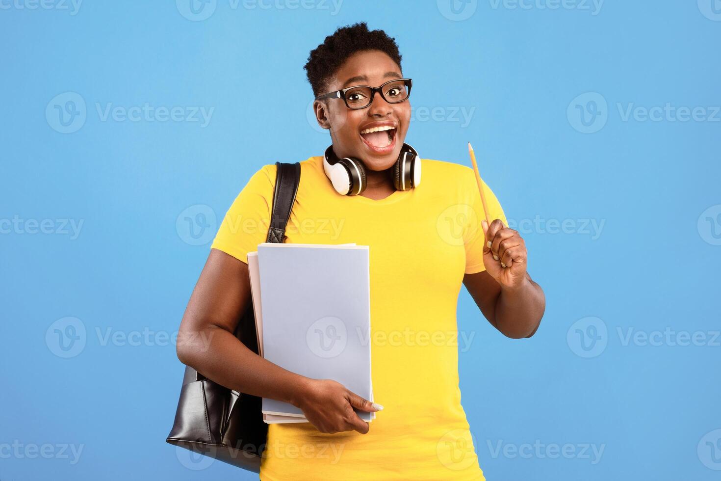 Great Idea. Excited Black Female Student Pointing Pencil Up Having Inspiration Moment Posing With Books Over Blue Studio Background. Eureka Concept. College And University Scholarship And Study photo