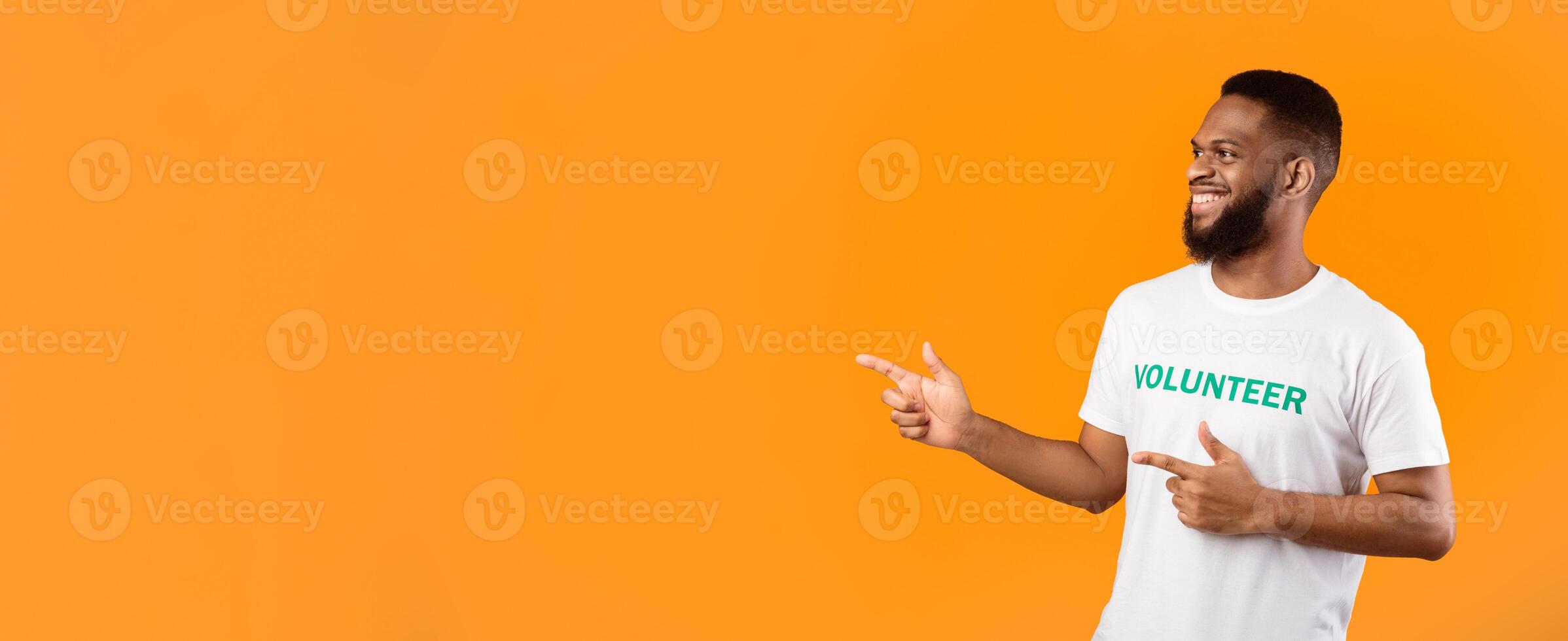 African American Male Volunteer Pointing Fingers Aside At Empty Space For Text Posing Standing Over Yellow Background, Studio Shot. Activist Guy Advertising Volunteering Project. Panorama photo