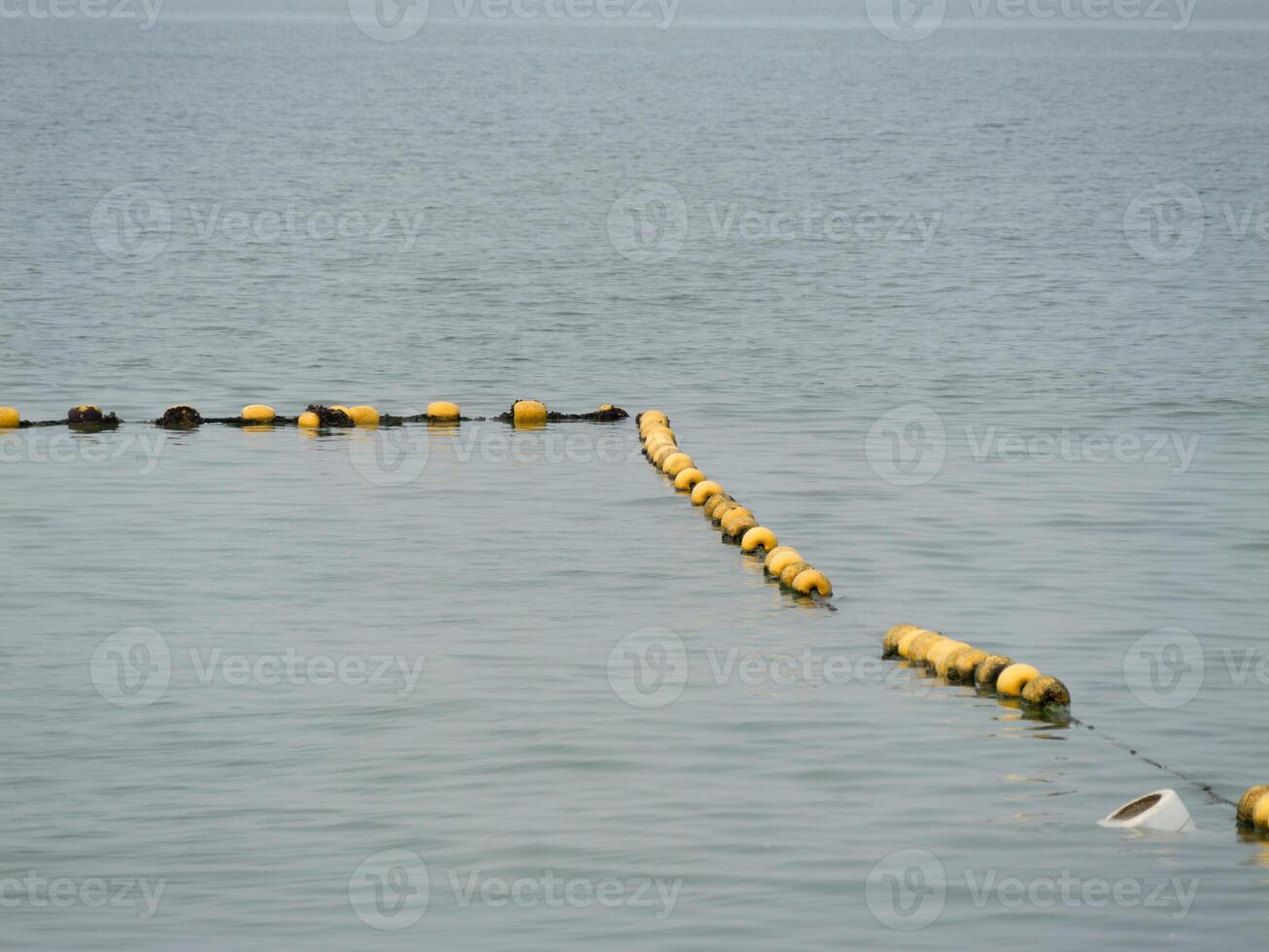 Floating buoys marking water boundaries coastal area calm waters aerial view marine safety photo