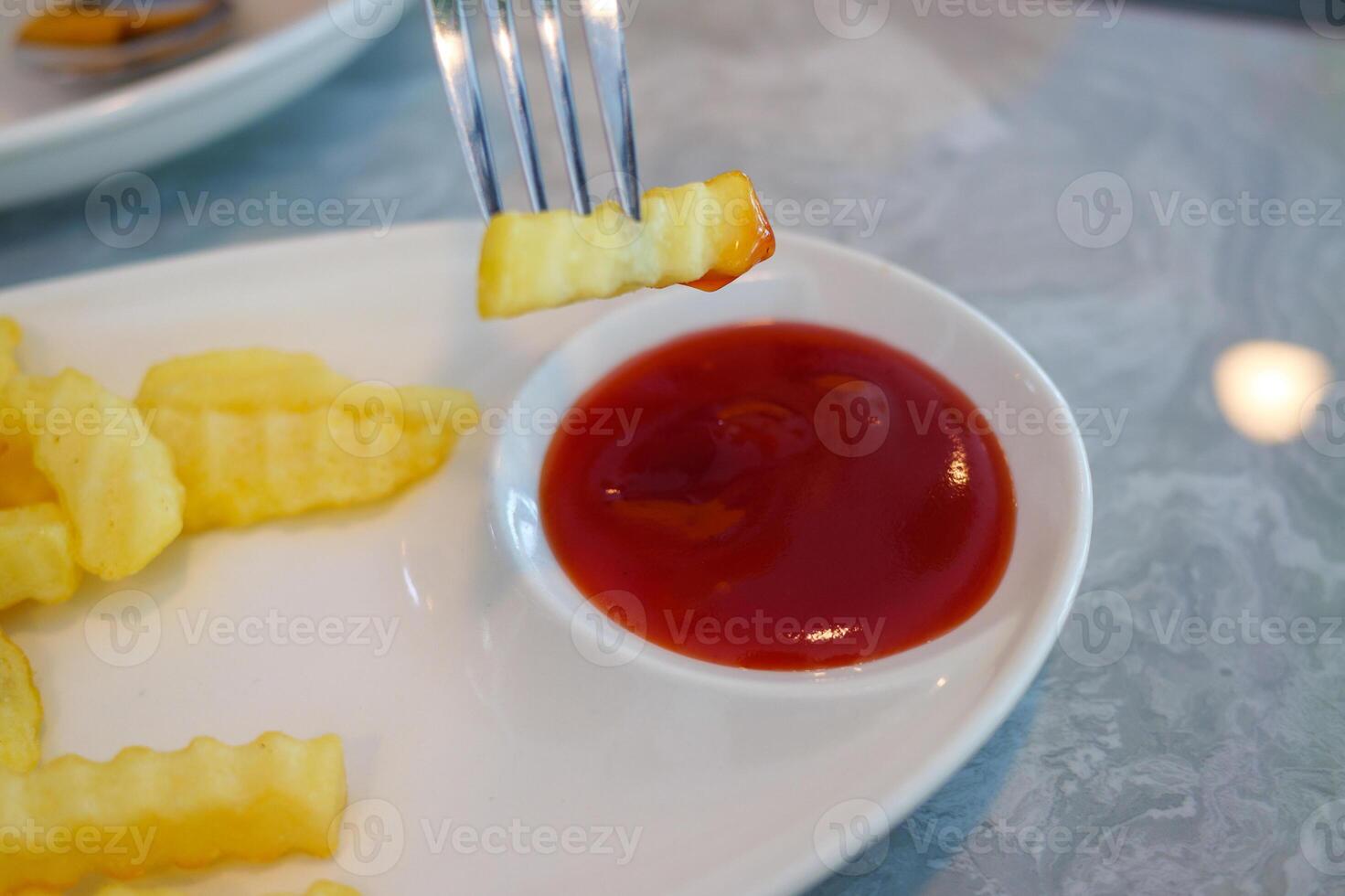 Delicious crinkle fries dipped in ketchup casual dining experience restaurant table close-up view photo