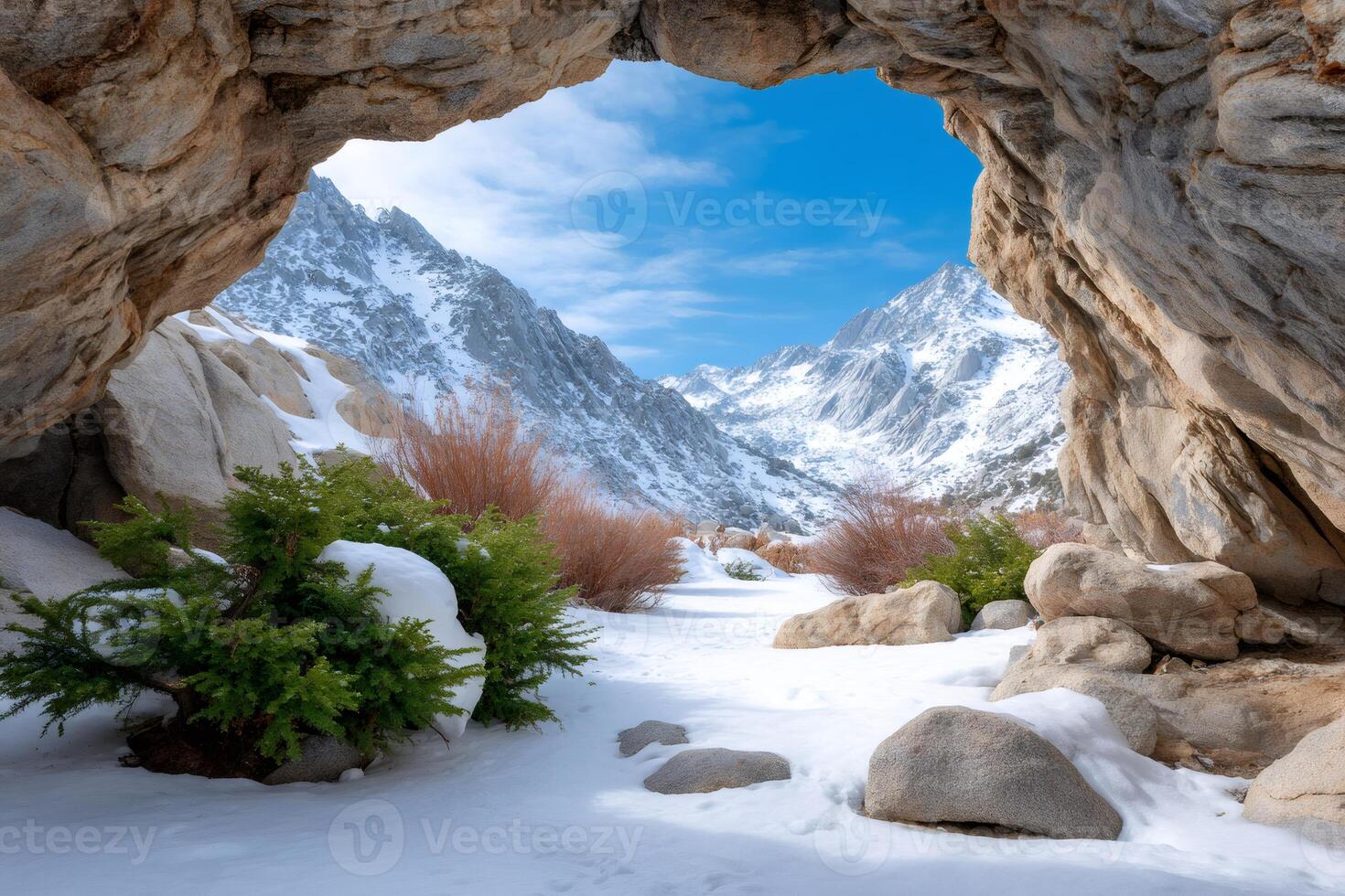 Discovering majestic snowy mountains through a natural rock arch photo