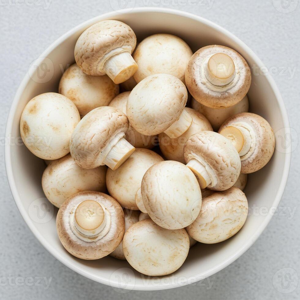 A bowl of fresh button mushrooms ready to be cooked. photo