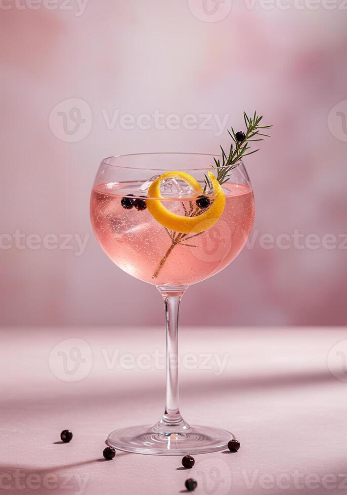 Elegant pink cocktail with a lemon twist garnish photo