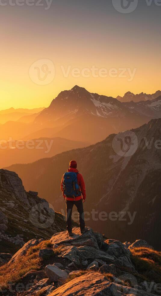 Hiker enjoying a stunning sunset view from a mountain peak photo