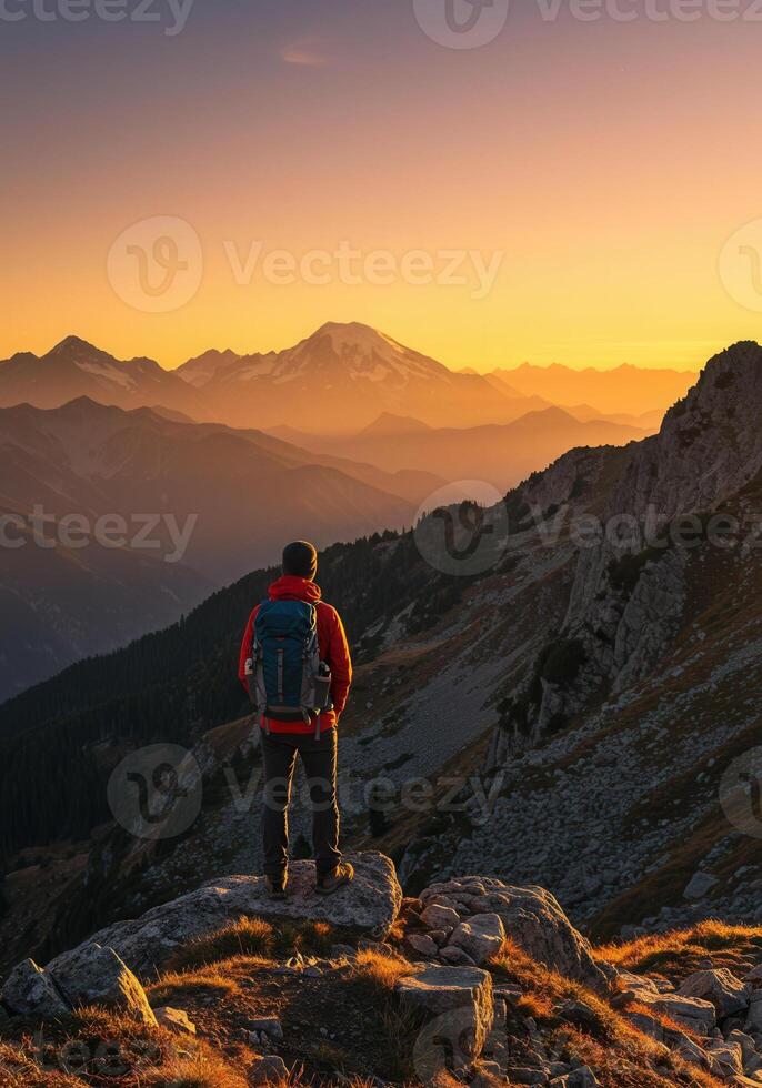Man enjoying the sunset view from a mountain peak photo