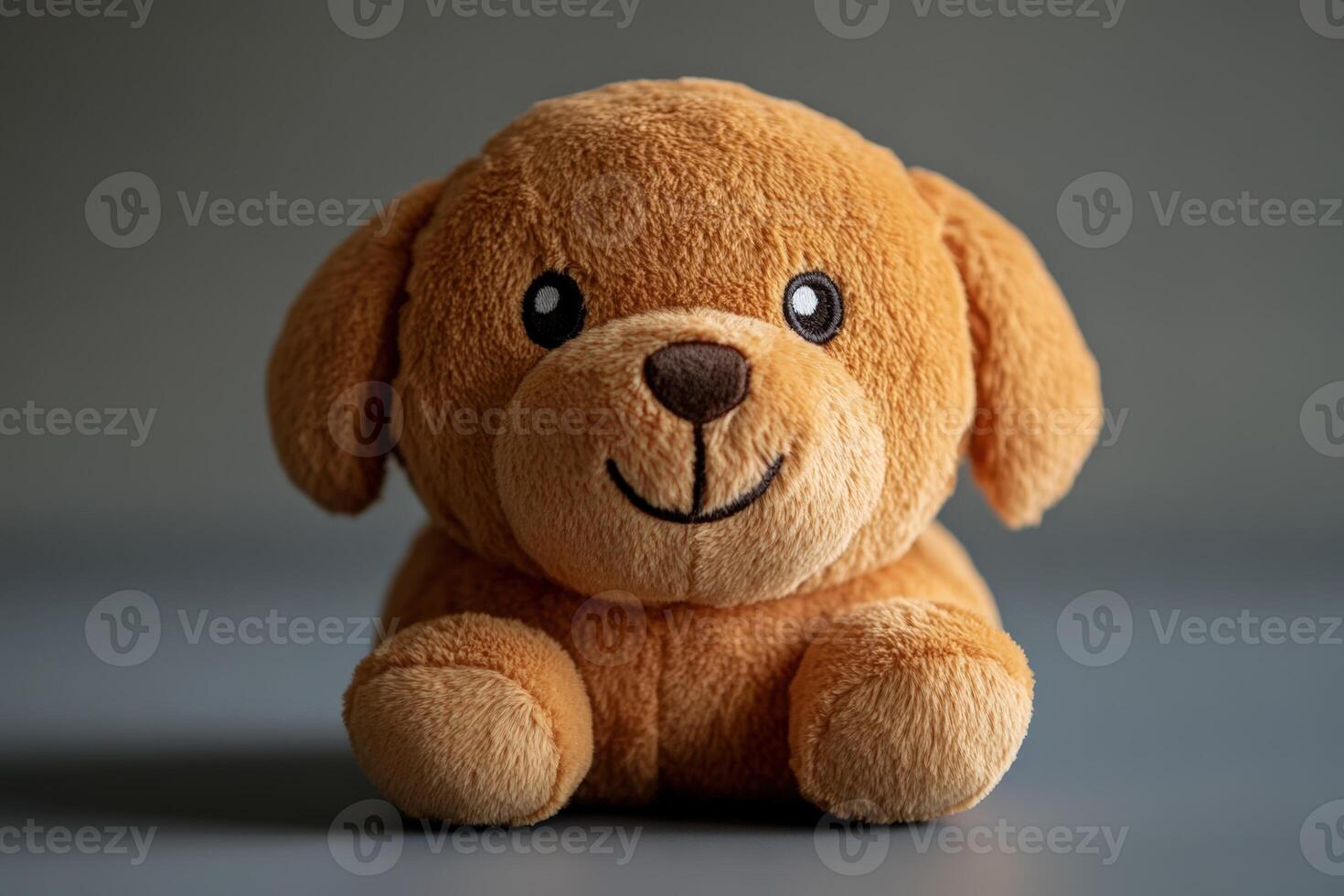 A brown stuffed dog sitting on a gray background photo