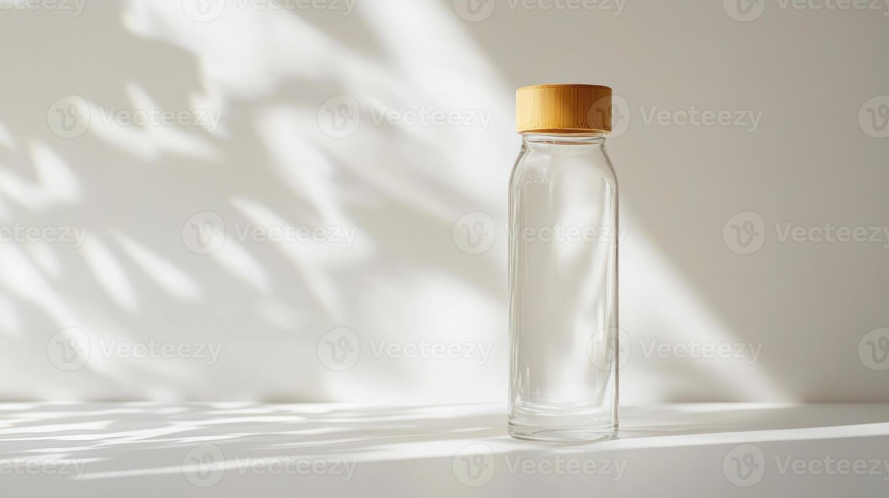 Empty glass bottle on white surface photo