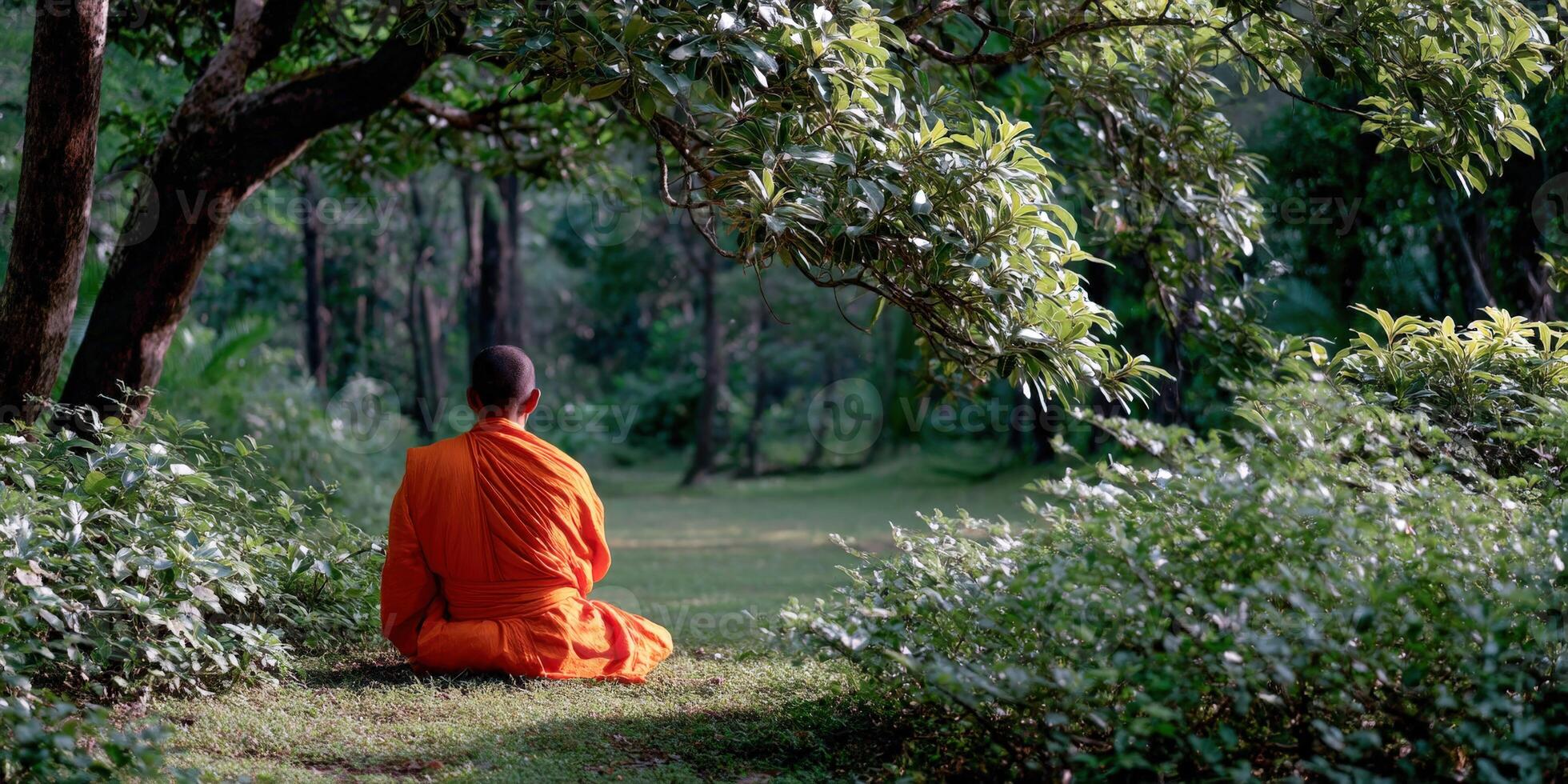 Monk in orange robes meditates peacefully in nature photo