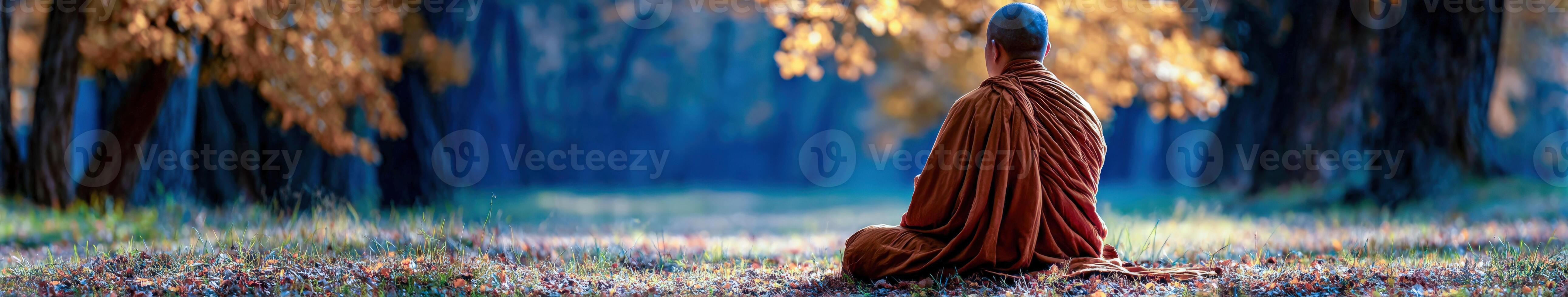 Monk meditates seated under trees during the late afternoon photo