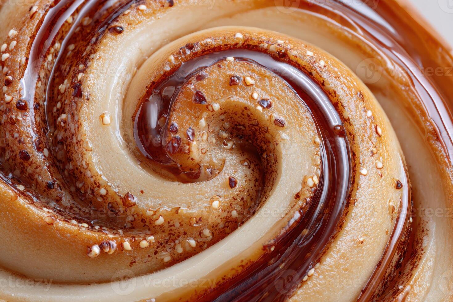Delicious cinnamon swirl pastry with flowing caramel topping creating a mesmerizing spiral pattern photo