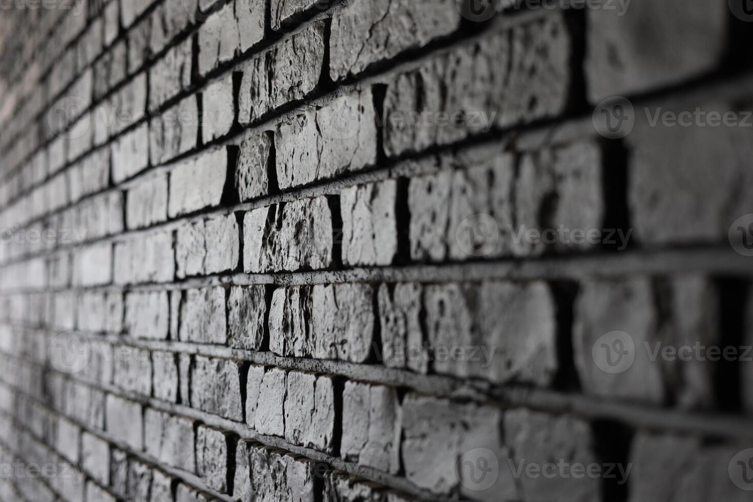 Texture and shadows of a black brick wall in an indoor setting during daylight photo