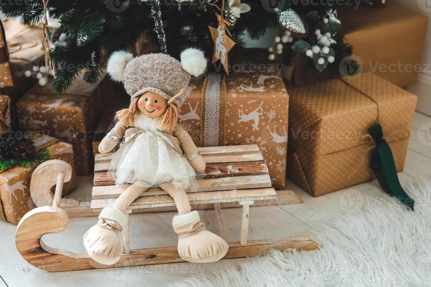 Christmas decoration with a doll on a wooden sled amidst wrapped gifts photo