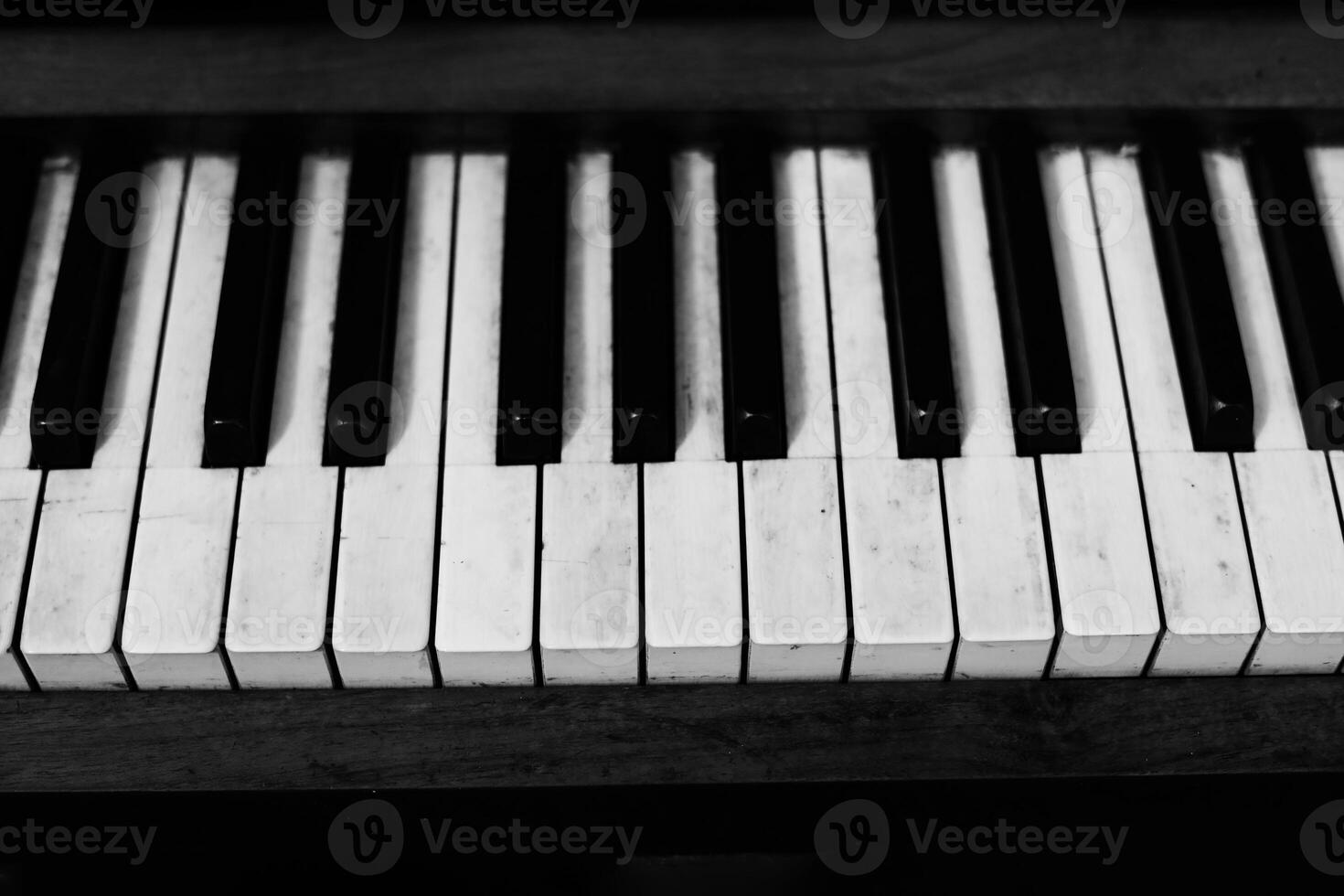 Detailed view of piano keys showcasing black and white keys with worn textures in a musical setting photo
