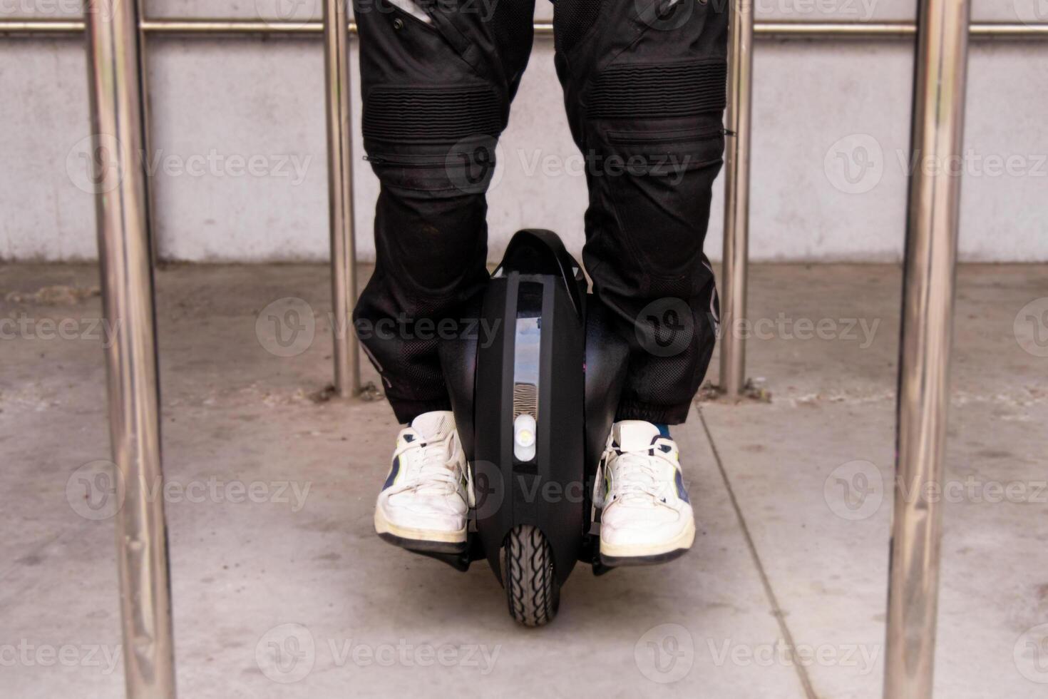 Individual riding a unicycle in a modern urban environment during daylight photo