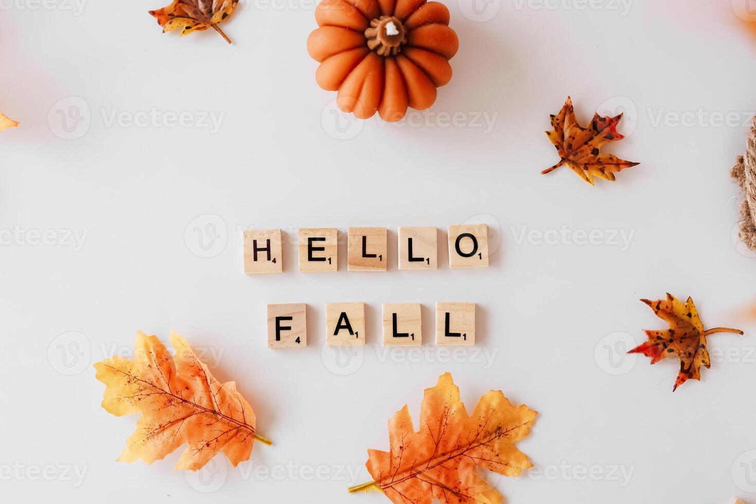 Autumn decoration with wooden blocks spelling hello fall and colorful leaves photo