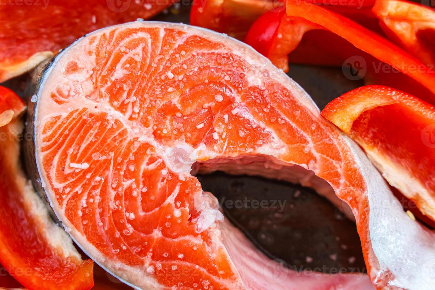Fresh salmon fillet with vibrant red bell peppers ready for cooking at home photo
