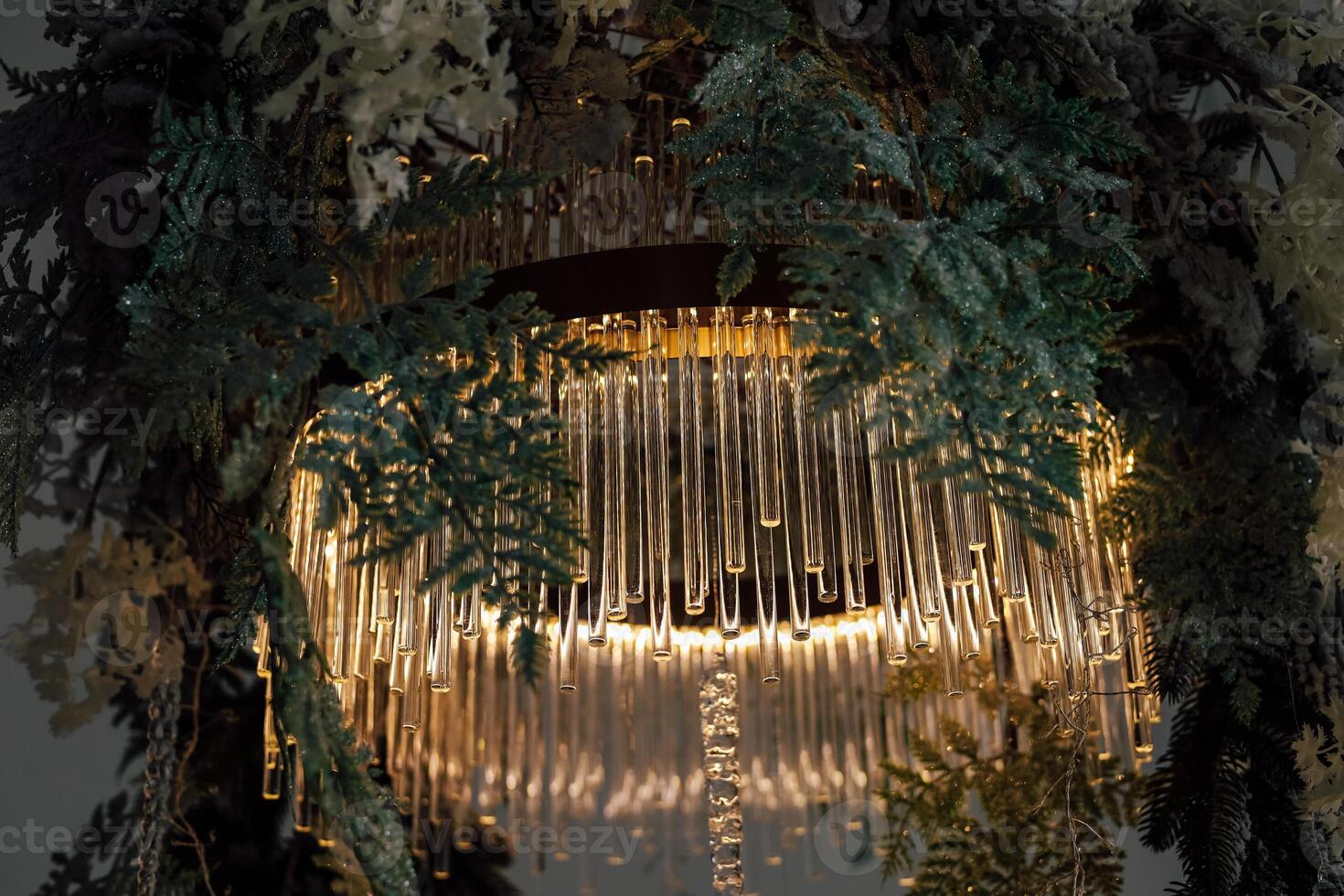Elegant chandelier adorned with greenery creates an enchanting atmosphere in a modern space photo
