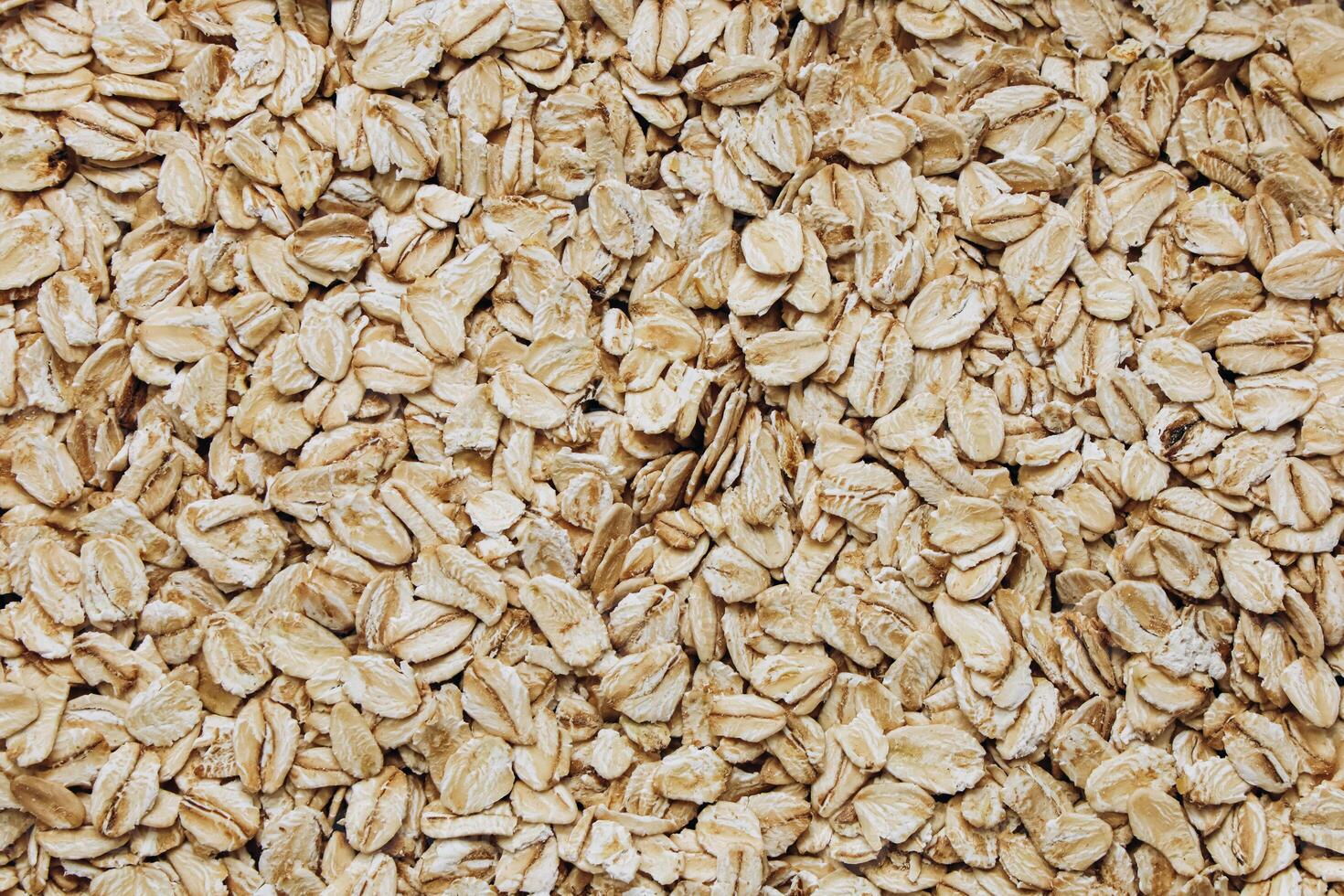 Oats spread across a surface highlighting their texture and natural color variations photo