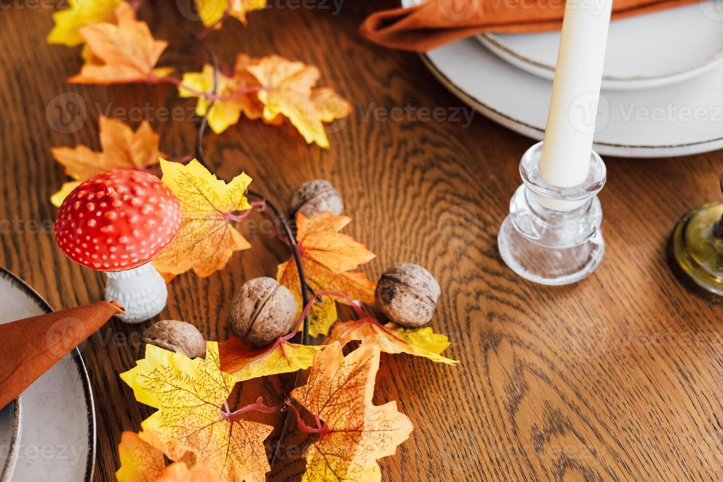Autumn table setting with leaves mushrooms and candles for seasonal gathering photo