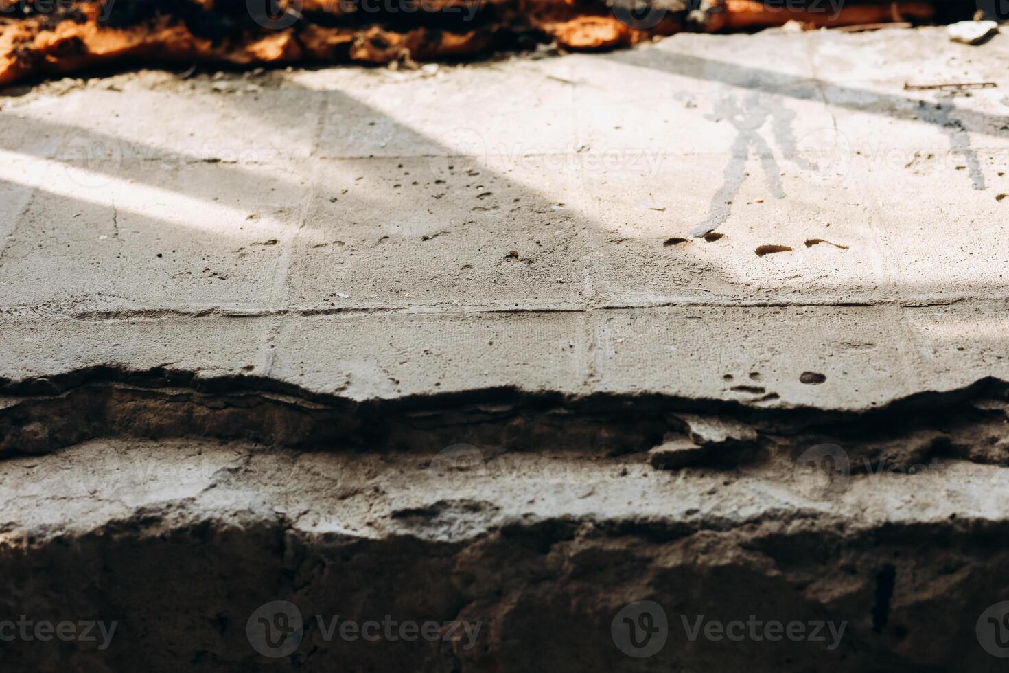 Textured concrete surface with shadows from nearby structures during daylight hours photo