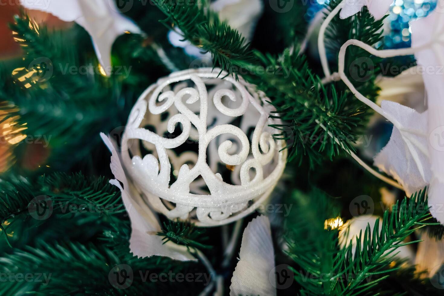 Delicate white ornament nestled among lush green Christmas tree branches photo