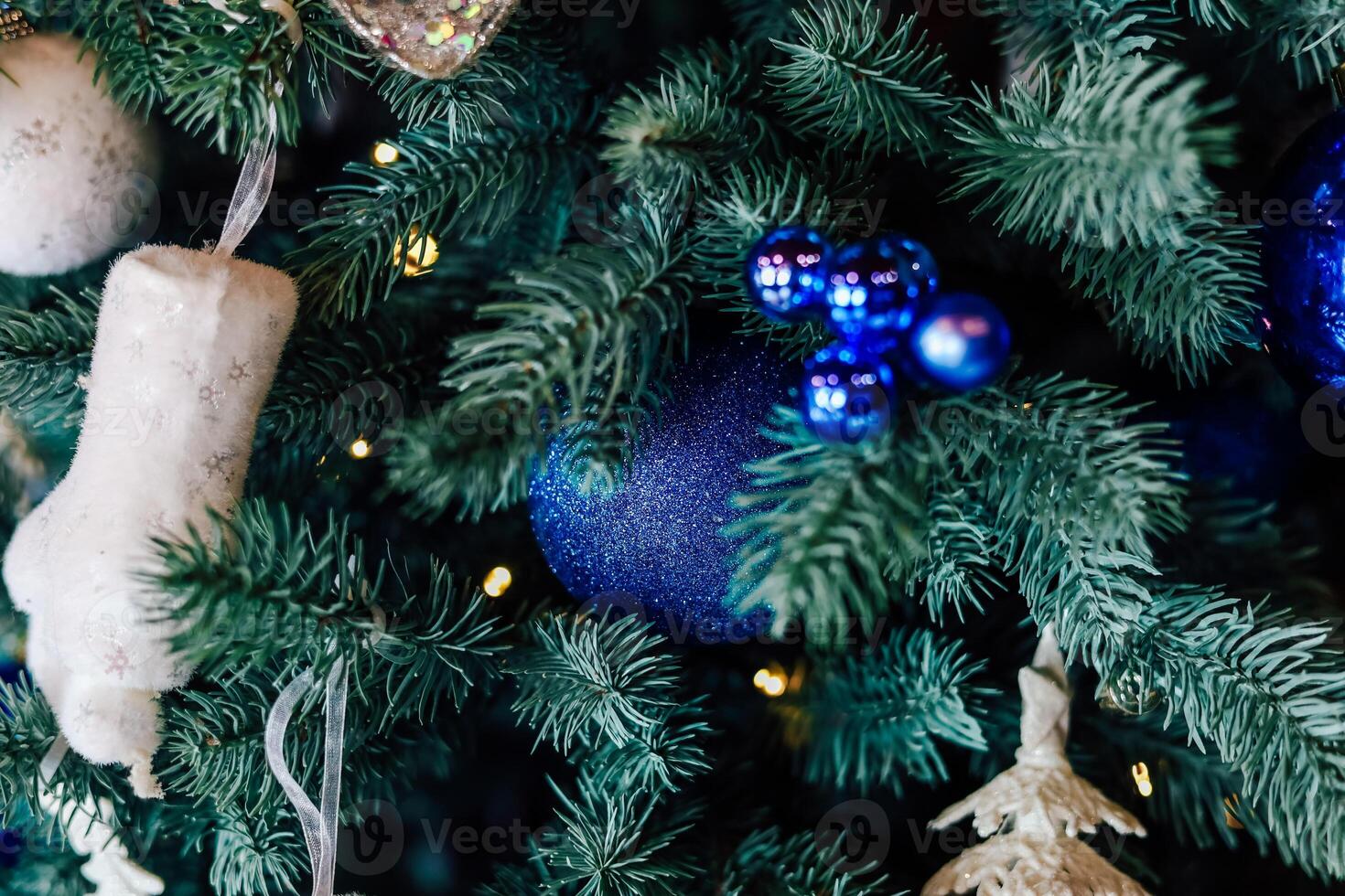 Bright blue ornaments and stockings adorn a festive Christmas tree in a cozy setting photo