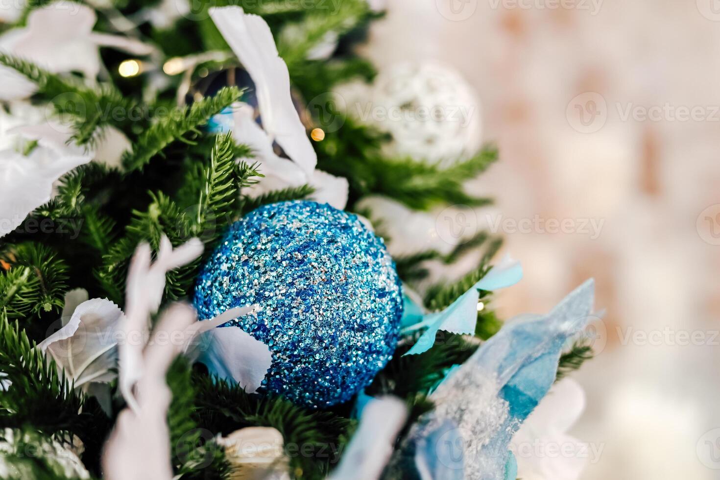 Beautiful blue glitter ornament on decorated Christmas tree with festive decorations photo