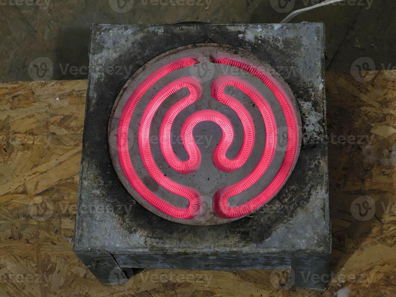 An old spiral electric stove with a red-hot heating element. photo